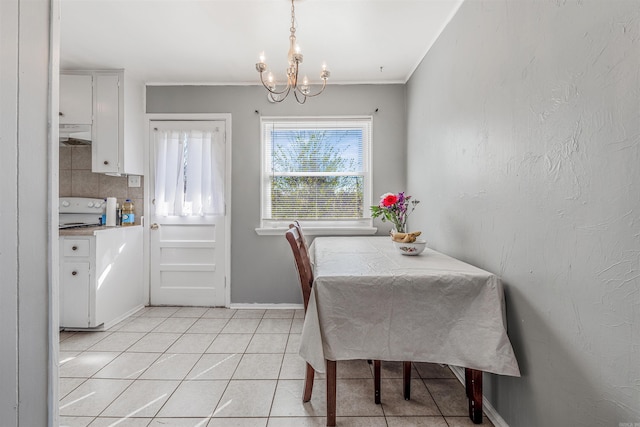 dining area featuring light tile patterned floors, crown molding, baseboards, and a notable chandelier