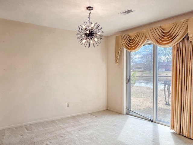 spare room featuring a chandelier, a textured ceiling, visible vents, and baseboards