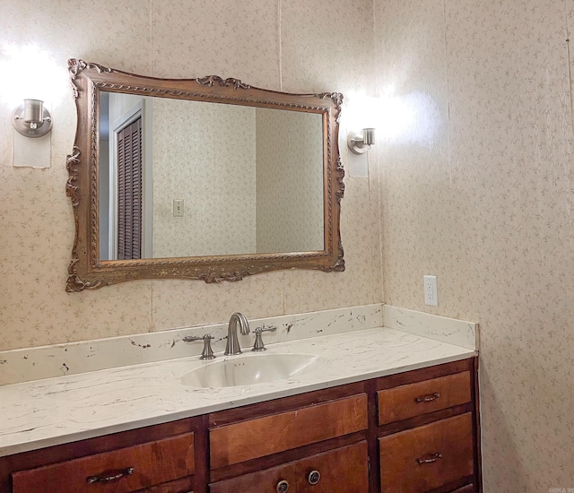 bathroom featuring vanity and wallpapered walls