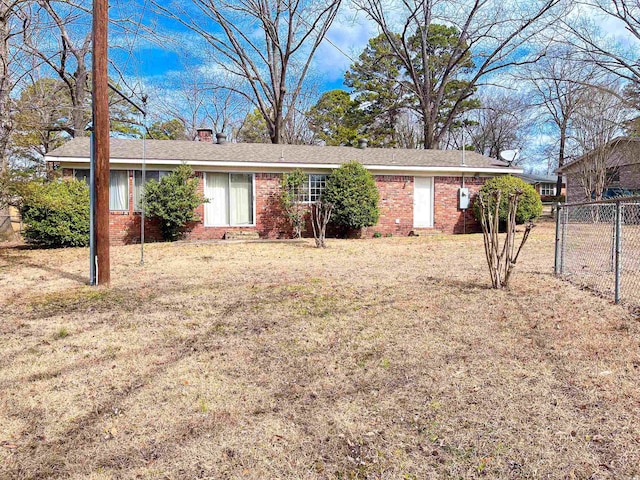 ranch-style house with brick siding, fence, a chimney, and a front lawn