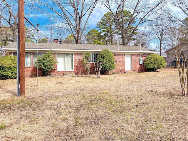 ranch-style house featuring a front yard and brick siding