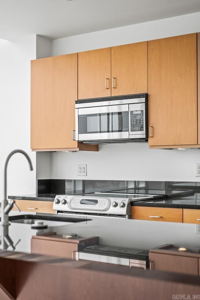 kitchen with stainless steel microwave and dark countertops