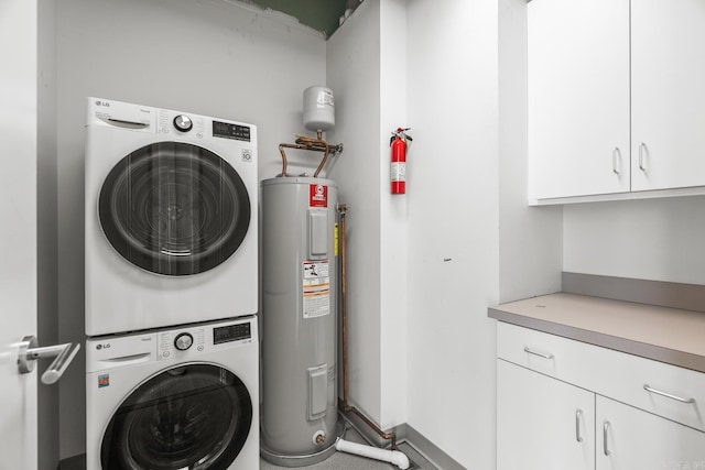 washroom featuring stacked washer and dryer, cabinet space, and electric water heater