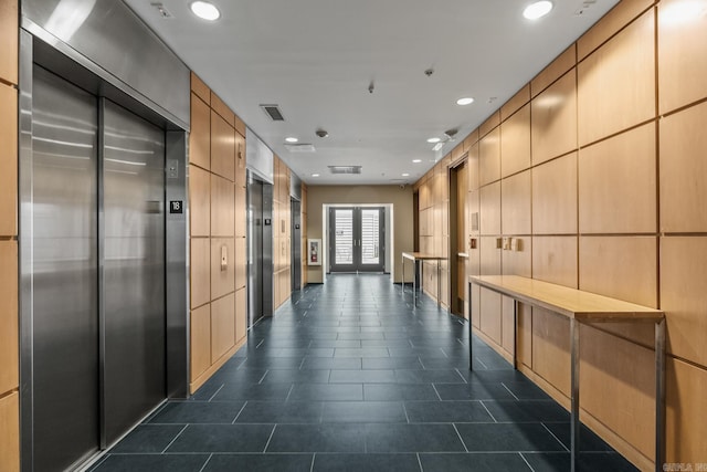 hallway with recessed lighting, dark tile patterned flooring, visible vents, french doors, and elevator