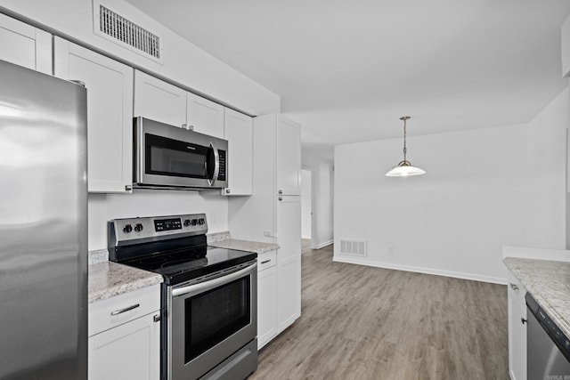 kitchen featuring stainless steel appliances, light wood-style flooring, visible vents, and white cabinetry