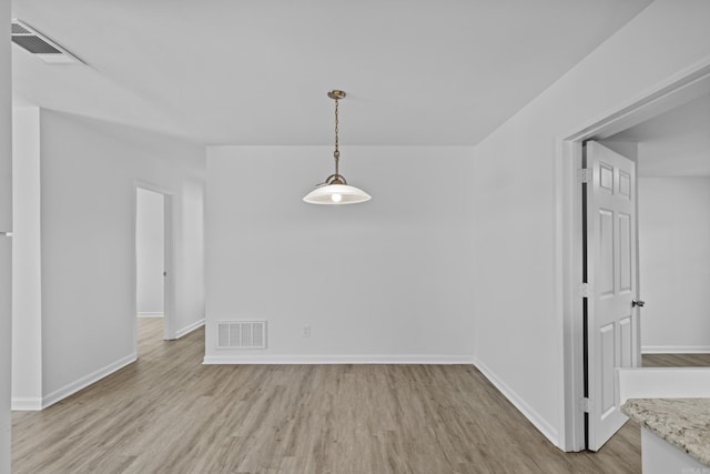 unfurnished dining area with light wood-style floors, baseboards, and visible vents