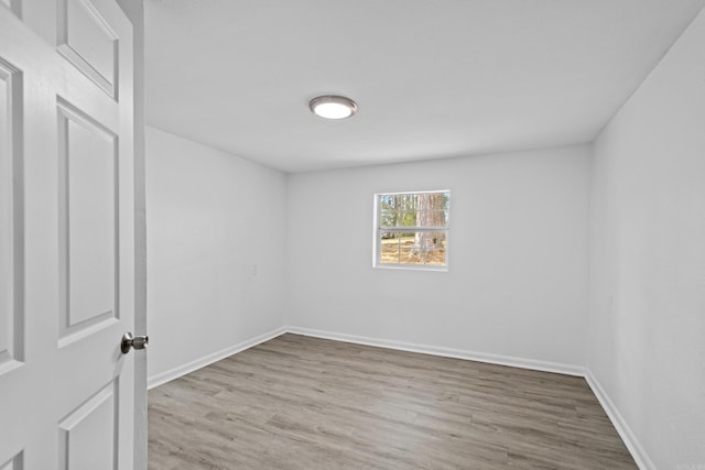 unfurnished room featuring baseboards and wood finished floors