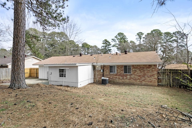 back of property with fence, cooling unit, and brick siding