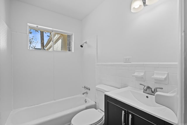 bathroom with a wainscoted wall, tile walls, shower / bathtub combination, toilet, and vanity