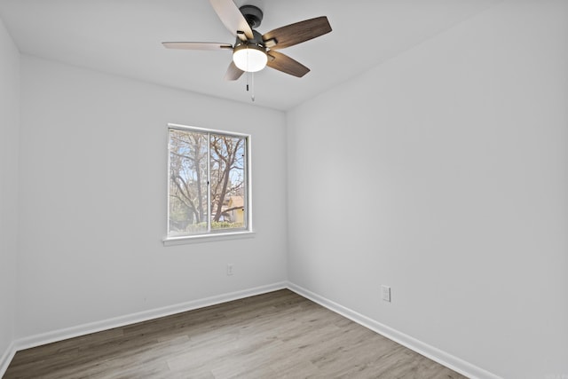 empty room featuring ceiling fan, baseboards, and wood finished floors