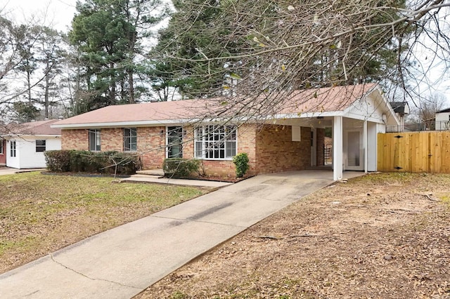 single story home featuring fence, a front lawn, an attached carport, and brick siding