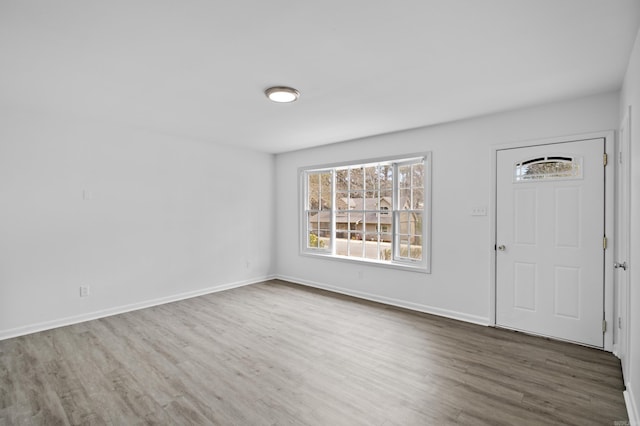 foyer entrance featuring baseboards and wood finished floors