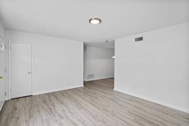 empty room featuring visible vents, baseboards, and wood finished floors