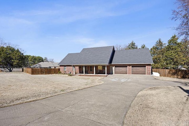 single story home with a garage, brick siding, fence, and driveway