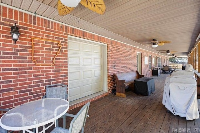 wooden deck featuring a ceiling fan and a garage