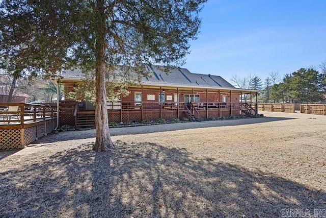 back of house with a wooden deck and fence