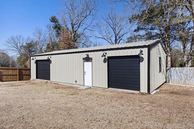 detached garage featuring fence