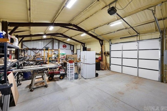 garage featuring a garage door opener and freestanding refrigerator