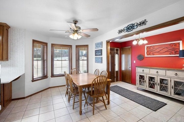 dining room with light tile patterned floors, baseboards, and ceiling fan with notable chandelier