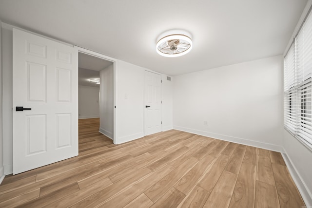 unfurnished bedroom featuring visible vents, light wood-style flooring, and baseboards