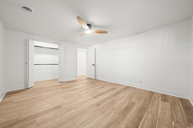 unfurnished bedroom featuring light wood-type flooring, baseboards, visible vents, and a closet