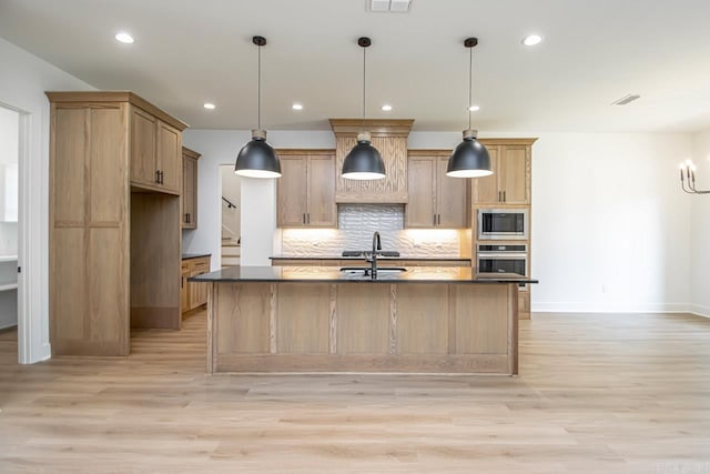 kitchen with stainless steel oven, light wood-style floors, built in microwave, and decorative backsplash