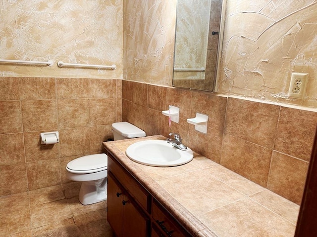 bathroom featuring toilet, tile walls, and vanity