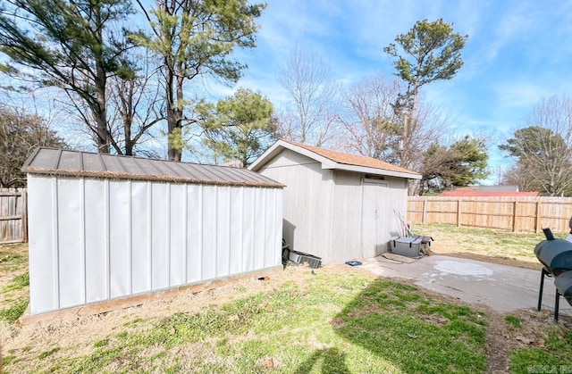 view of yard with an outdoor structure, a fenced backyard, a patio, and a storage shed