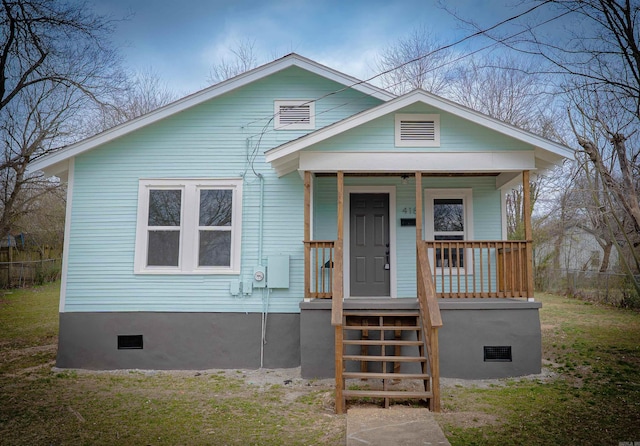 bungalow-style home with covered porch, a front lawn, crawl space, and fence