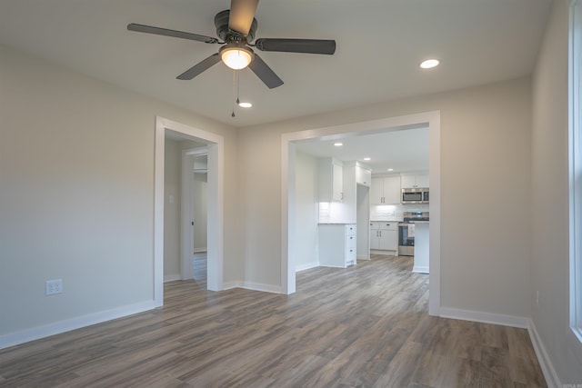 unfurnished room featuring a ceiling fan, recessed lighting, baseboards, and wood finished floors