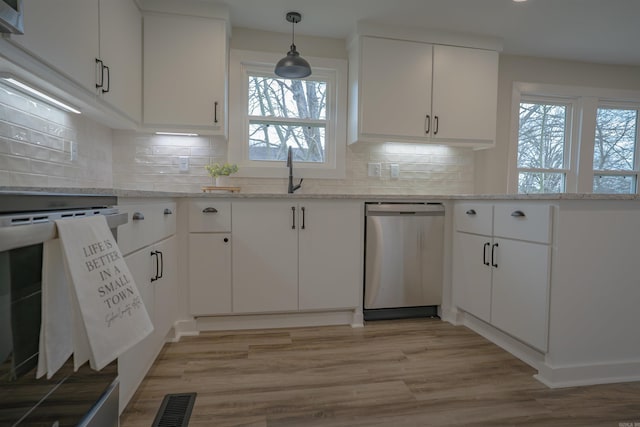 kitchen with a sink, light stone countertops, white cabinetry, and stainless steel dishwasher