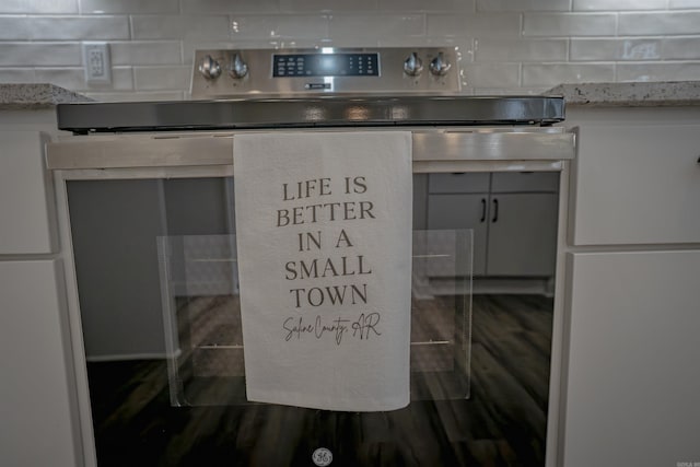 details featuring dark wood-style floors, tasteful backsplash, and stainless steel electric range