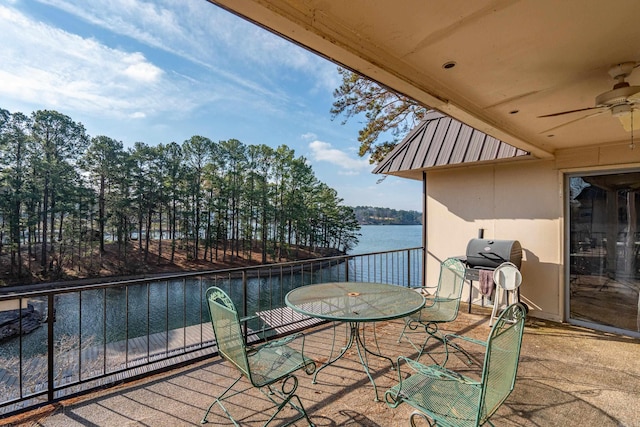 exterior space featuring grilling area, a ceiling fan, and a water view