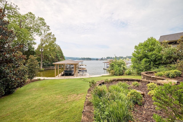 view of yard featuring a water view, a boat dock, and boat lift