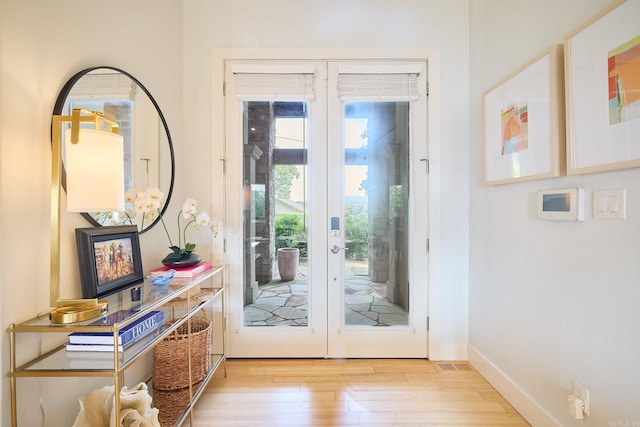 entryway featuring light wood-type flooring, baseboards, and french doors