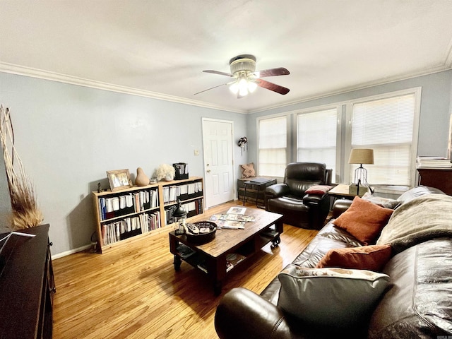 living room featuring light wood-type flooring, ceiling fan, baseboards, and crown molding