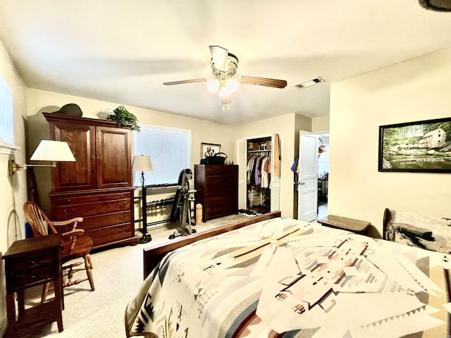 bedroom with ceiling fan, visible vents, a closet, and light colored carpet