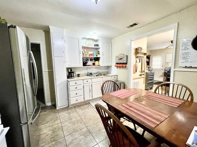 dining space featuring ceiling fan, visible vents, and light tile patterned flooring