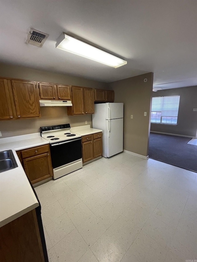 kitchen featuring under cabinet range hood, electric range, visible vents, freestanding refrigerator, and light floors