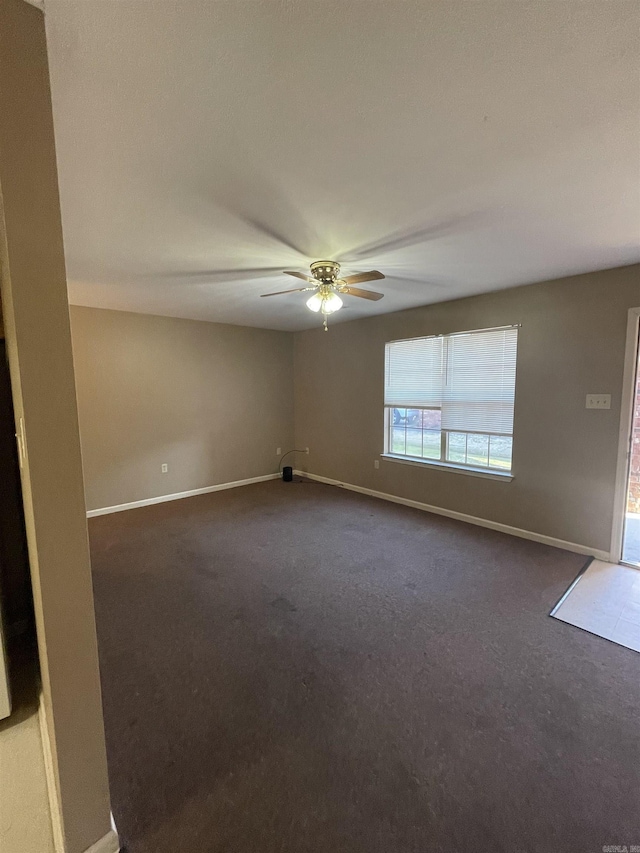 spare room with ceiling fan and baseboards