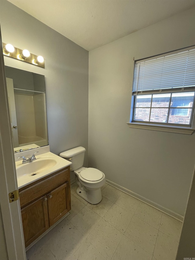 full bathroom featuring toilet, vanity, baseboards, tile patterned floors, and walk in shower