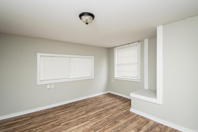 spare room with wood finished floors and baseboards