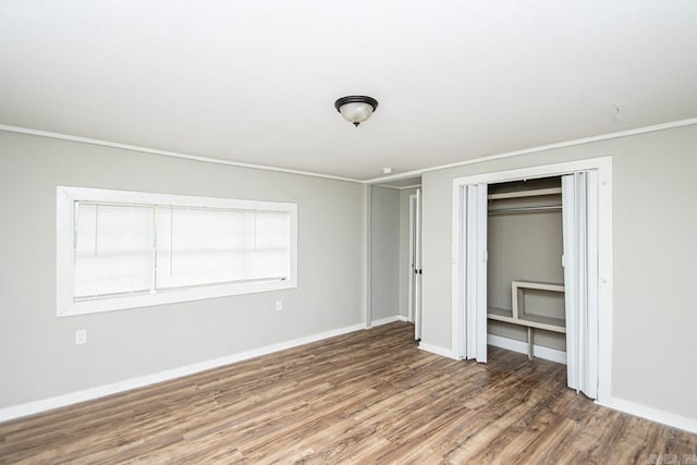 unfurnished bedroom featuring a closet, baseboards, and wood finished floors