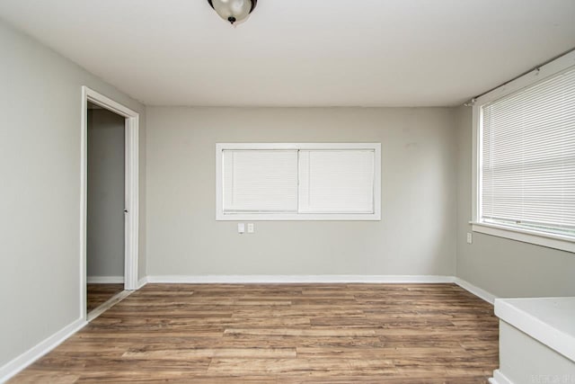 unfurnished room featuring baseboards and wood finished floors