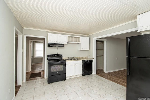 kitchen with light countertops, white cabinetry, a sink, under cabinet range hood, and black appliances