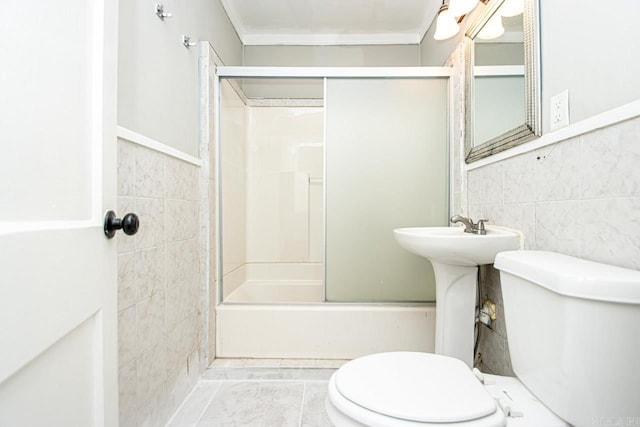 bathroom with combined bath / shower with glass door, tile walls, and toilet