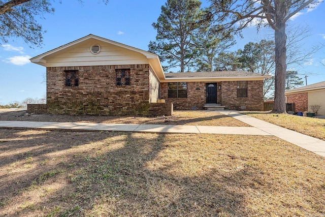 view of front of home with brick siding and a front lawn