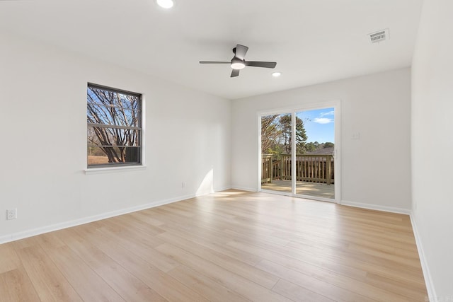 empty room featuring light wood-style flooring, visible vents, baseboards, and recessed lighting