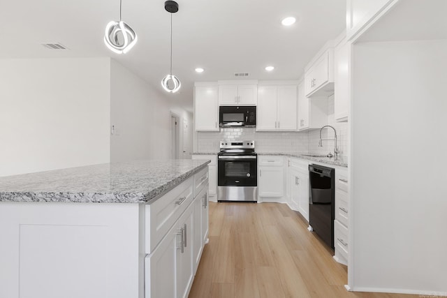 kitchen with light wood finished floors, visible vents, a sink, black appliances, and backsplash