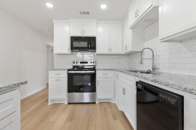 kitchen with visible vents, light wood-type flooring, black appliances, white cabinetry, and a sink